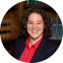 Photo of Abigail L. Roach in front of a bookshelf.