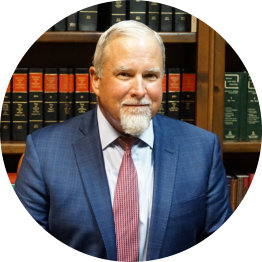 Photo of Thomas A. Roach, Jr. in front of a bookshelf.